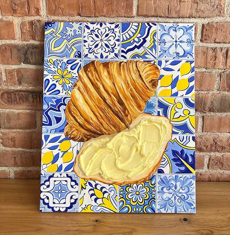 A drawing of a cut croissant on a plate with a tile pattern