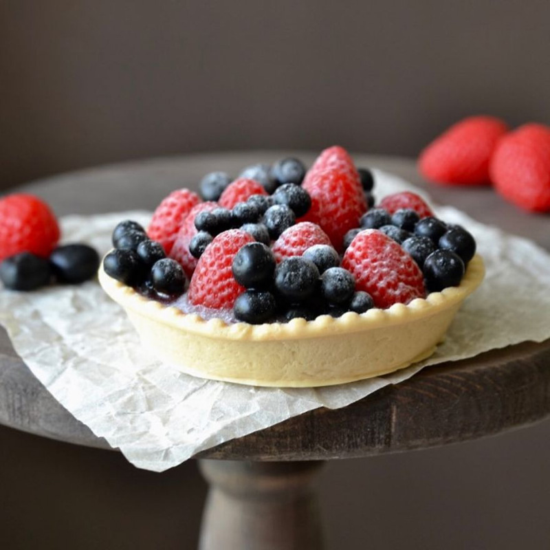 Soap in the form of a tart with toppings of different types of berries 