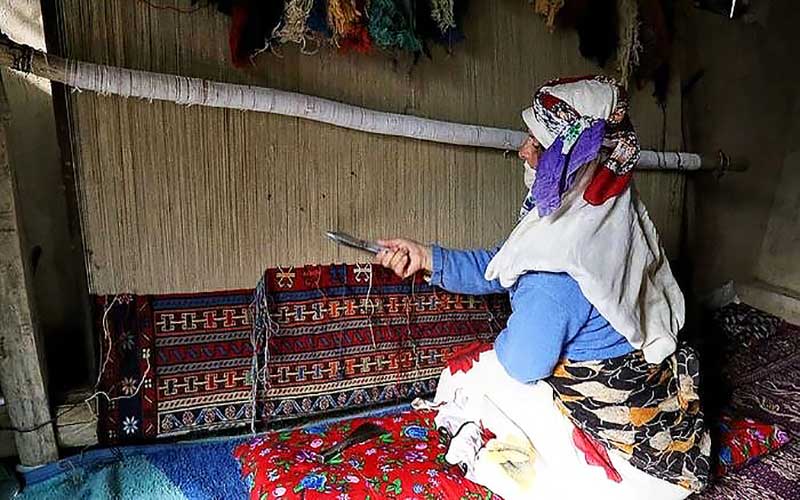 Weaving of a rug with a vertical hanging by a village woman; Photo source: totikala; Name of the photographer: unknown