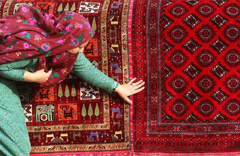 Turkmen woman next to the carpet; Photo source: totikala; Name of the photographer: unknown