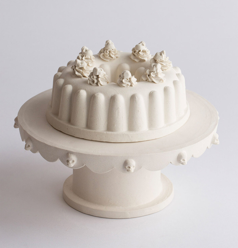 A porcelain statue of a cream cake on a stand