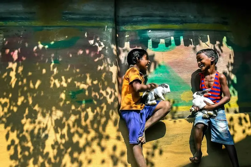 Two Indian children with rabbits in their arms 