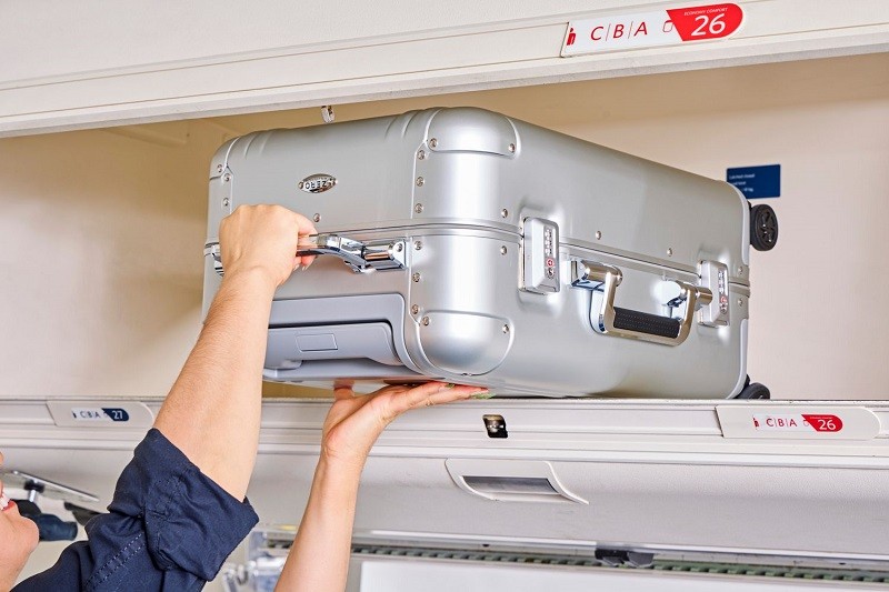 placing the size cabin luggage in the cabin compartment of the plane; Photo source: Travel + Leisure website. Photographer: Unknown