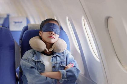 Tourist sleeping with a neck pillow and blindfold in the airplane seat, photo source: NBC news website, photographer: unknown