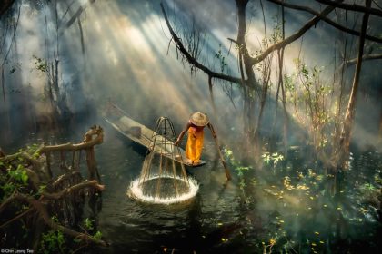 Asian fisherman in the forest river