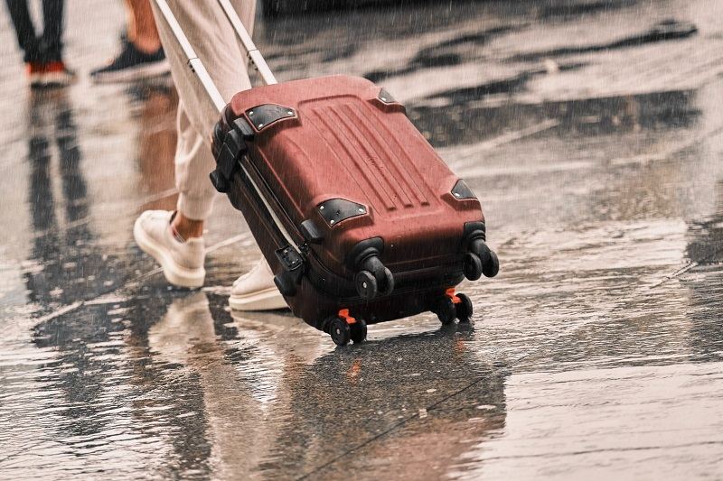 traveling with luggage in rainy weather; Photo source: Explore.com website. Photographer: Unknown