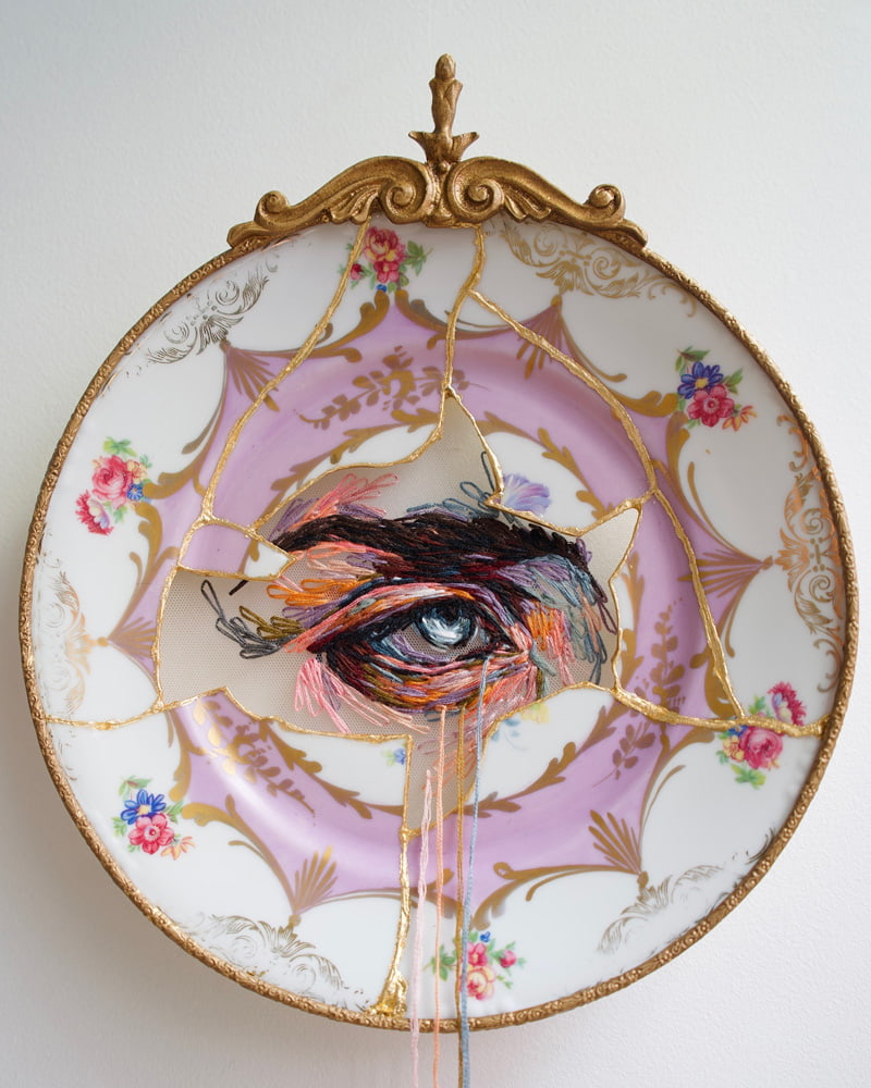 An eye design on an embroidered porcelain plate