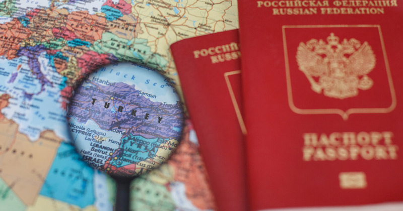 Russian passports and a map of Europe and a magnifying glass on the map of Türkiye; Photo Source: Antalya Tourist Information, Photographer: Unknown