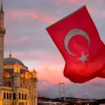 Turkish flag with the background of Ortakoy Mosque and Bosphorus Bridge; Photo Source: Visas Association, Photographer: Unknown