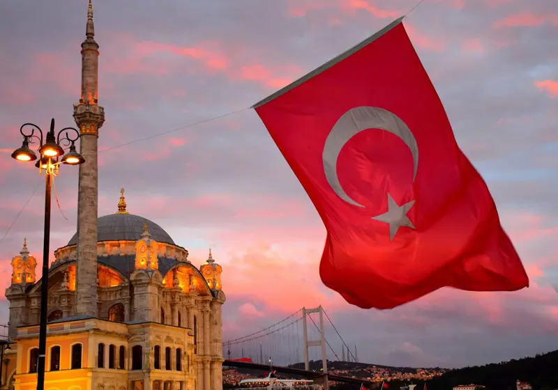 Turkish flag with the background of Ortakoy Mosque and Bosphorus Bridge; Photo Source: Visas Association, Photographer: Unknown
