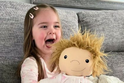 A little girl with a golden hair doll