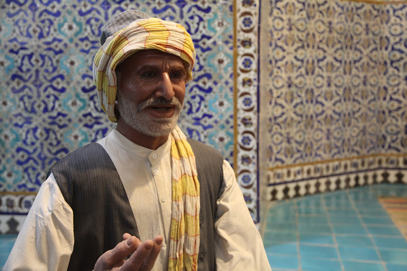 A statue of a man with a yellow and white dosage in Ganjali Khan Kerman bath; Photographer: Mohammad Shojaee