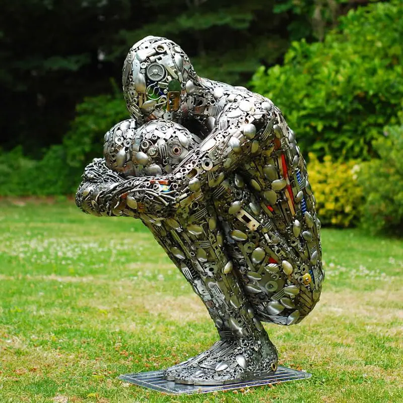 The sculpture of a sad man with recycled materials
