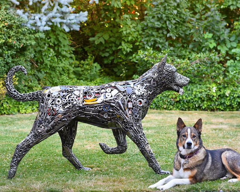 Doggy next to the statue of a recycled dog