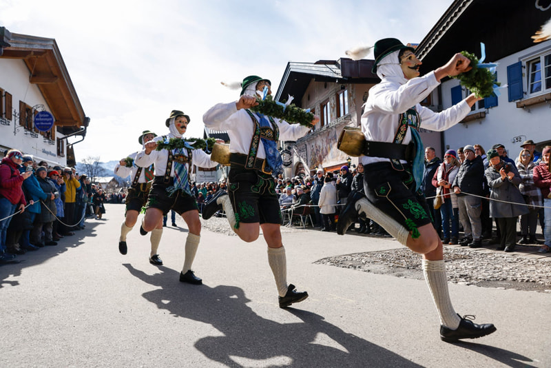 Men with traditional costumes and wooden masks on the annual carnival parade in Germany; Photo Source: Theguardian; Name of Photographer: Michaela Stache
