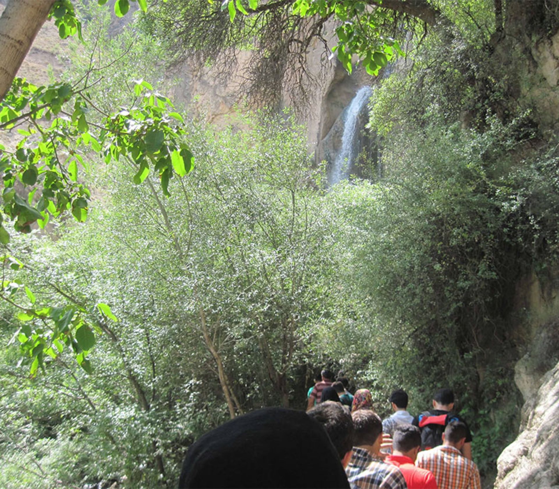Tourists on the path of Shahandasht Waterfall