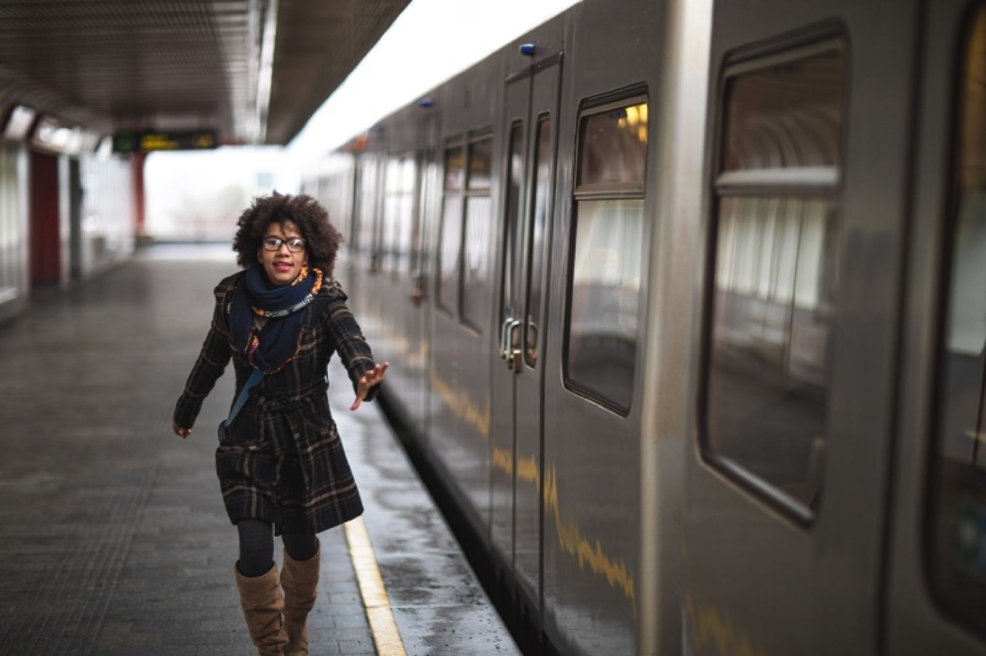 The female passenger with winter clothes beside the train