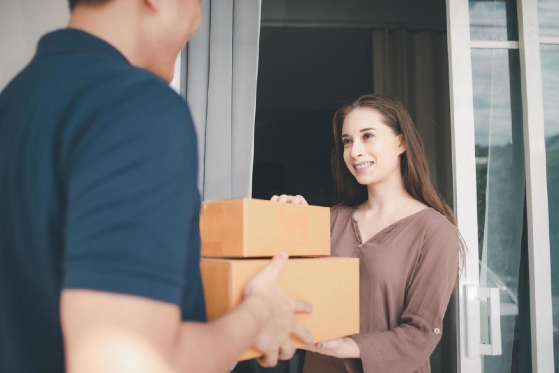 A woman receiving two postal packages