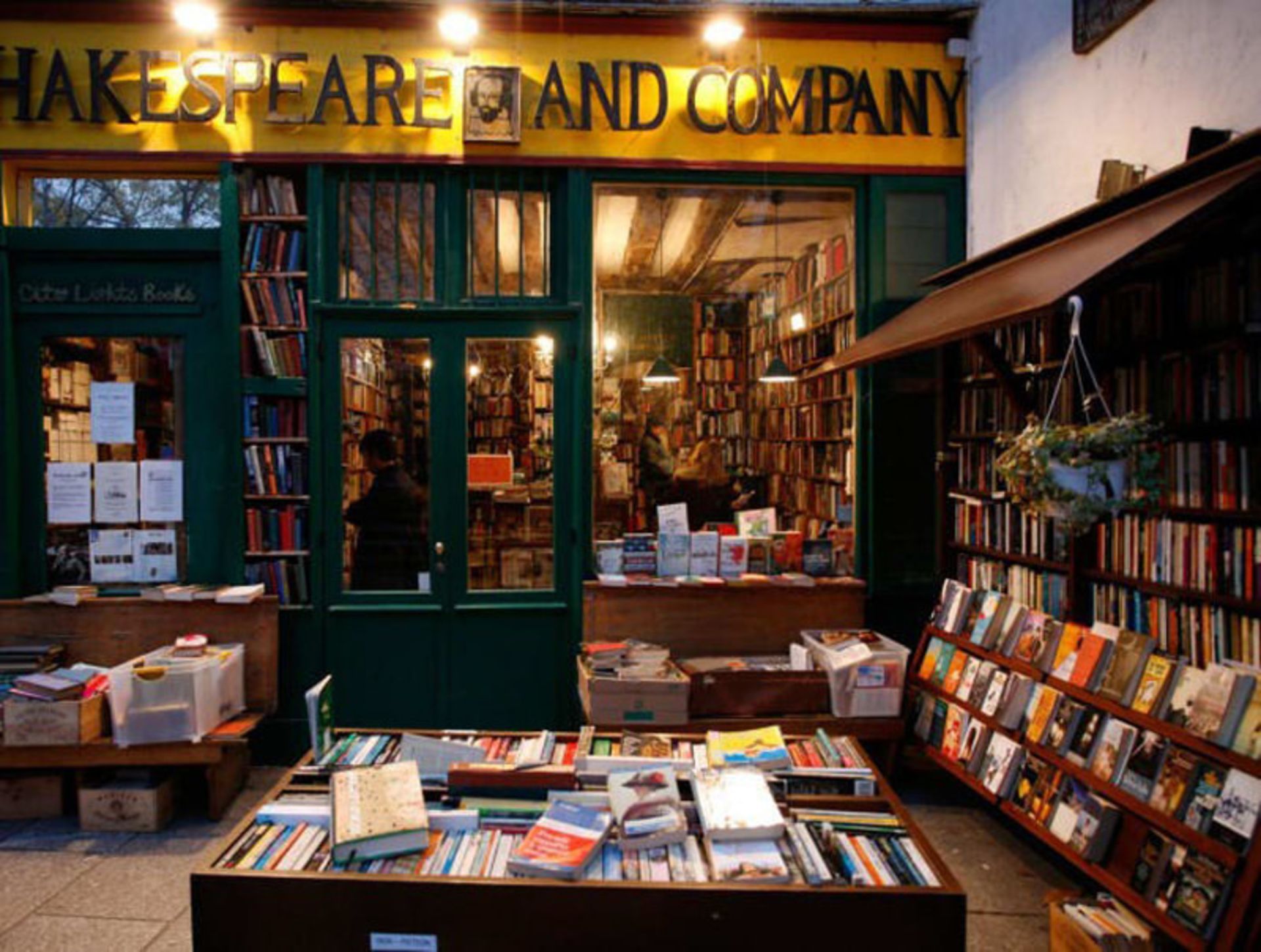 Exterior of Shakespeare and Partners Bookstore in Paris, with books full of books inside and outside the shop 