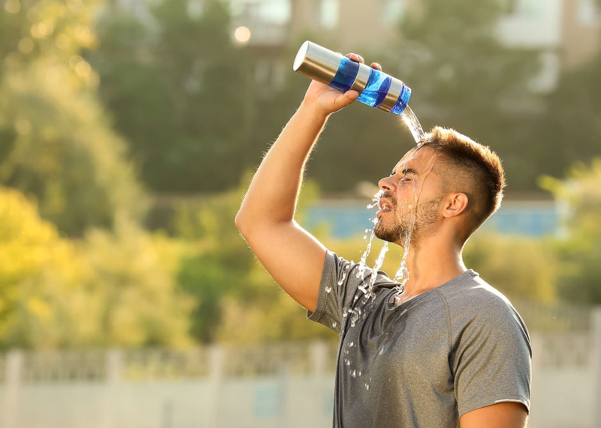 European man pouring water on his head in warm air