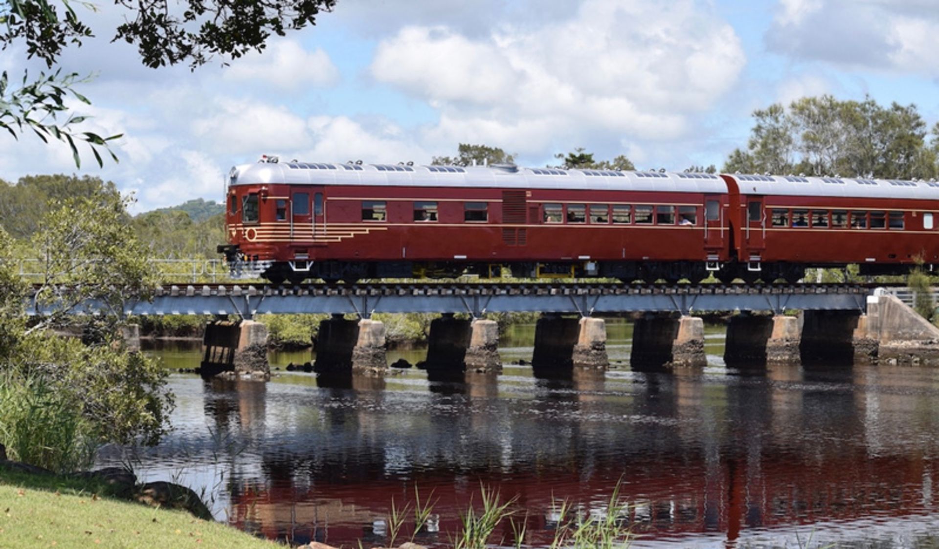 Reflection of the solar train by the Biron Bay in the river crossing the bridge