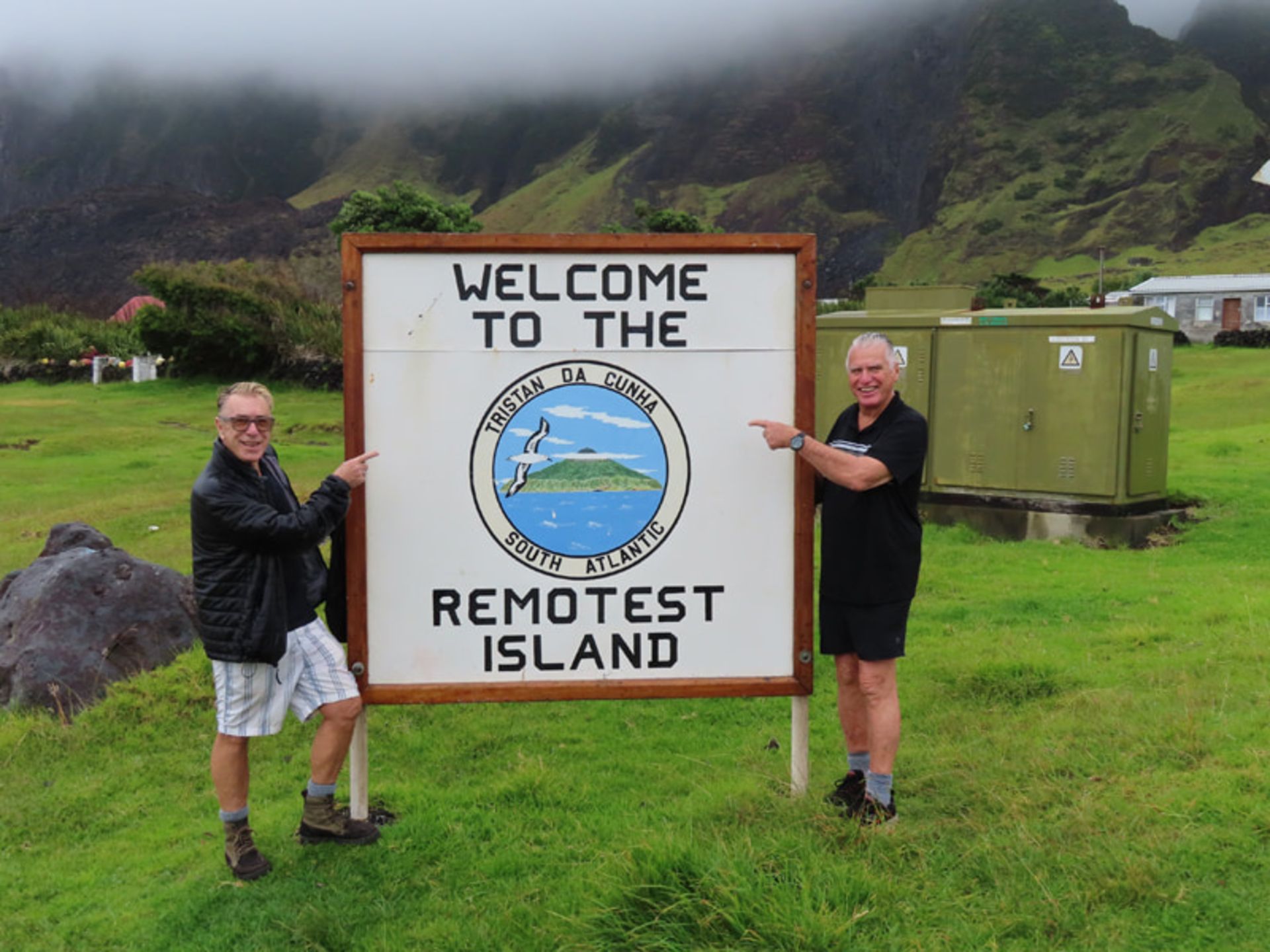 Two men along with a welcome sign to triumpha