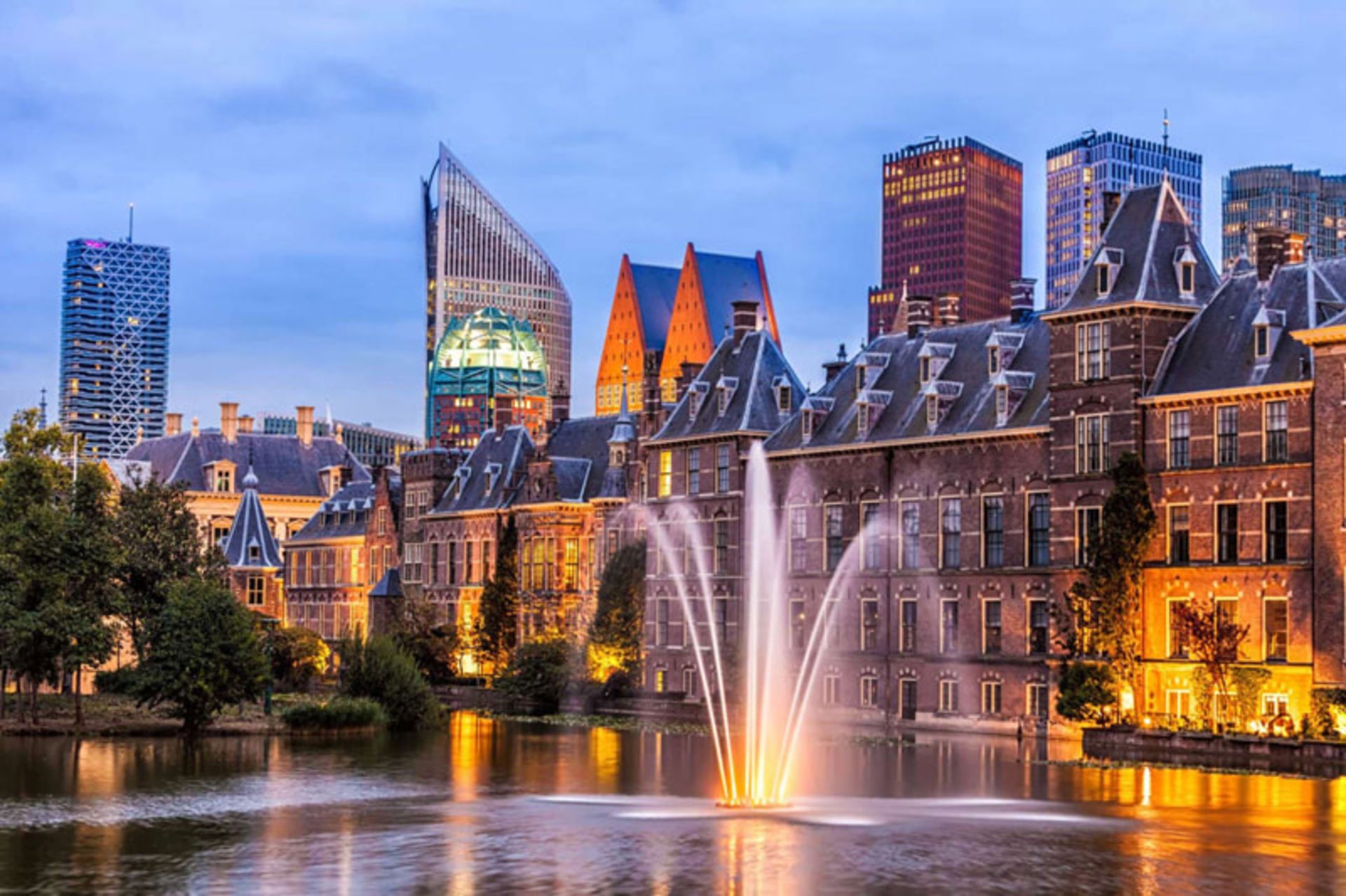 Hague at sunset with a bright fountain and historical buildings
