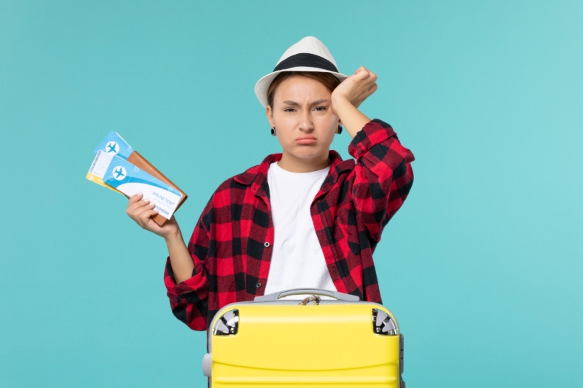 The upset traveler next to the yellow suitcase 