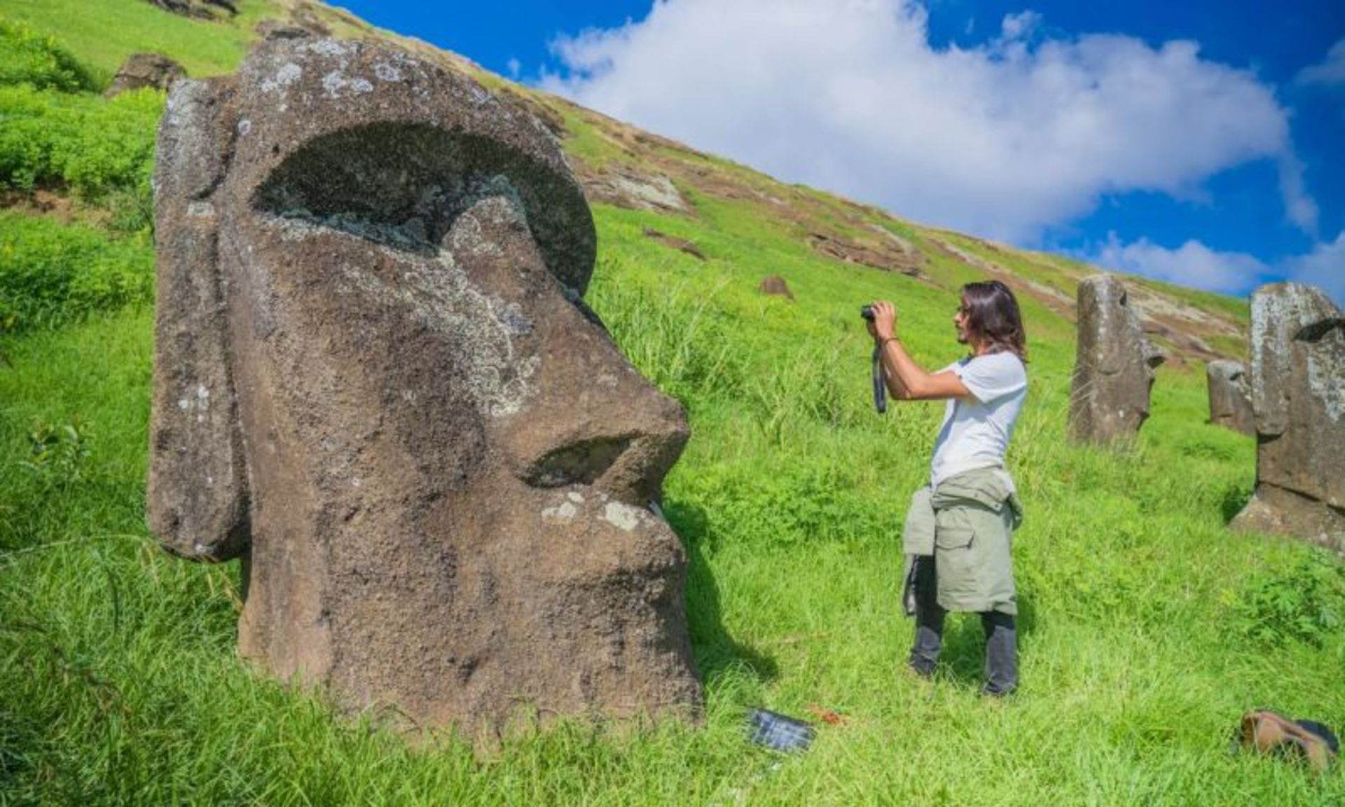 Tourist photographing a Mo'i statue