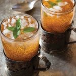 Two glasses of ash syrup with ice and mint leaves