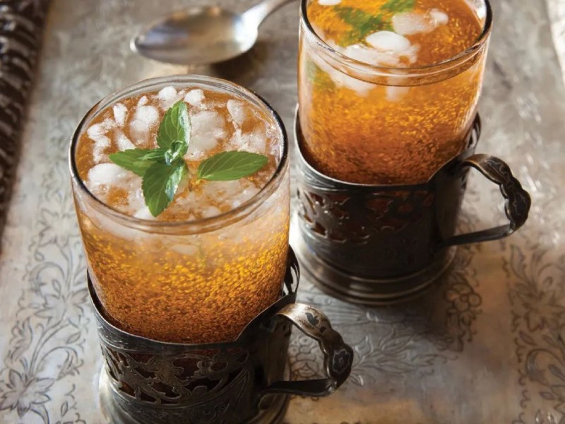 Two glasses of ash syrup with ice and mint leaves