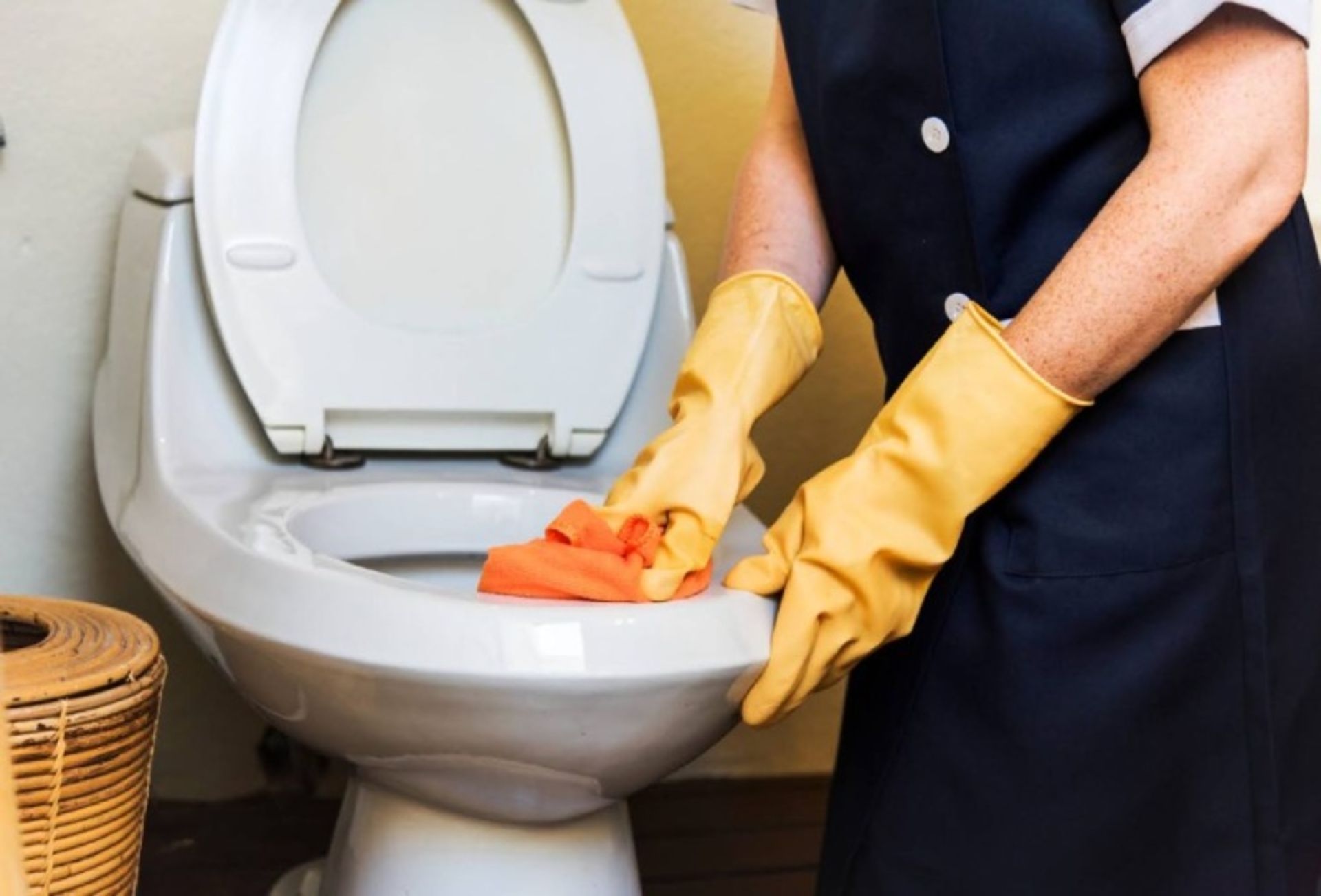 Service working while cleaning toilets with gloves