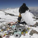 A person is collecting garbage in the snowy Everest Mountain