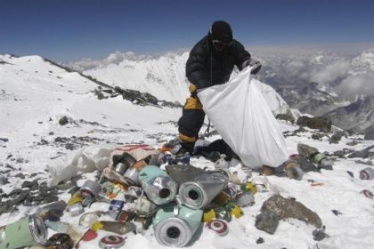 A person is collecting garbage in the snowy Everest Mountain