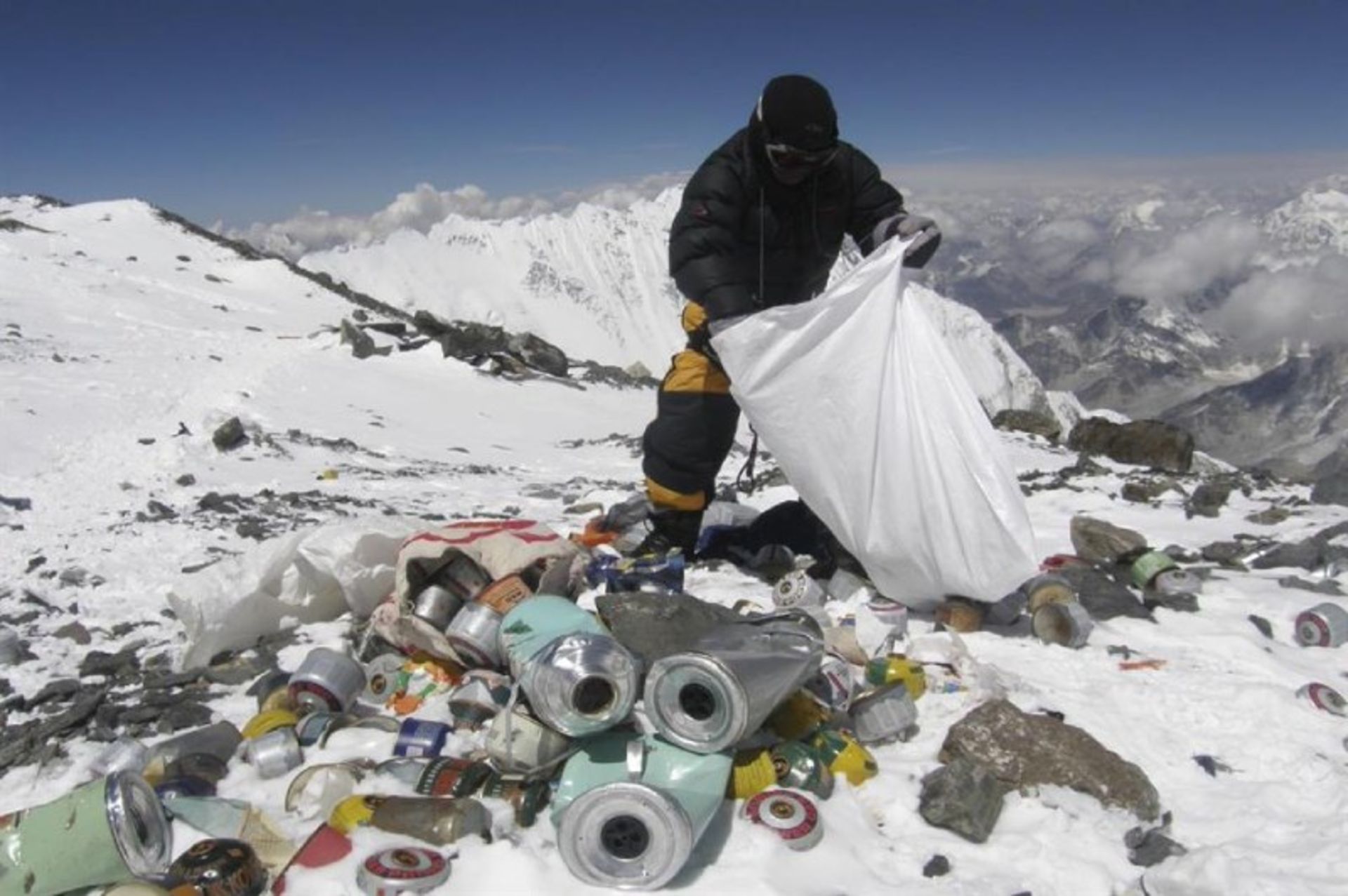 A person is collecting garbage in the snowy Everest Mountain
