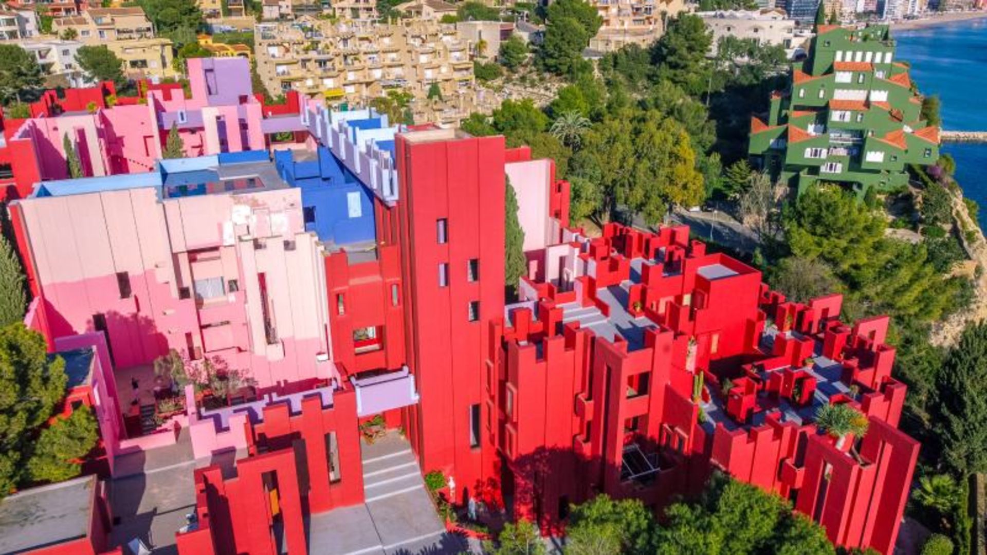 The pink building of the Red Wall of Spain and the surrounding nature
