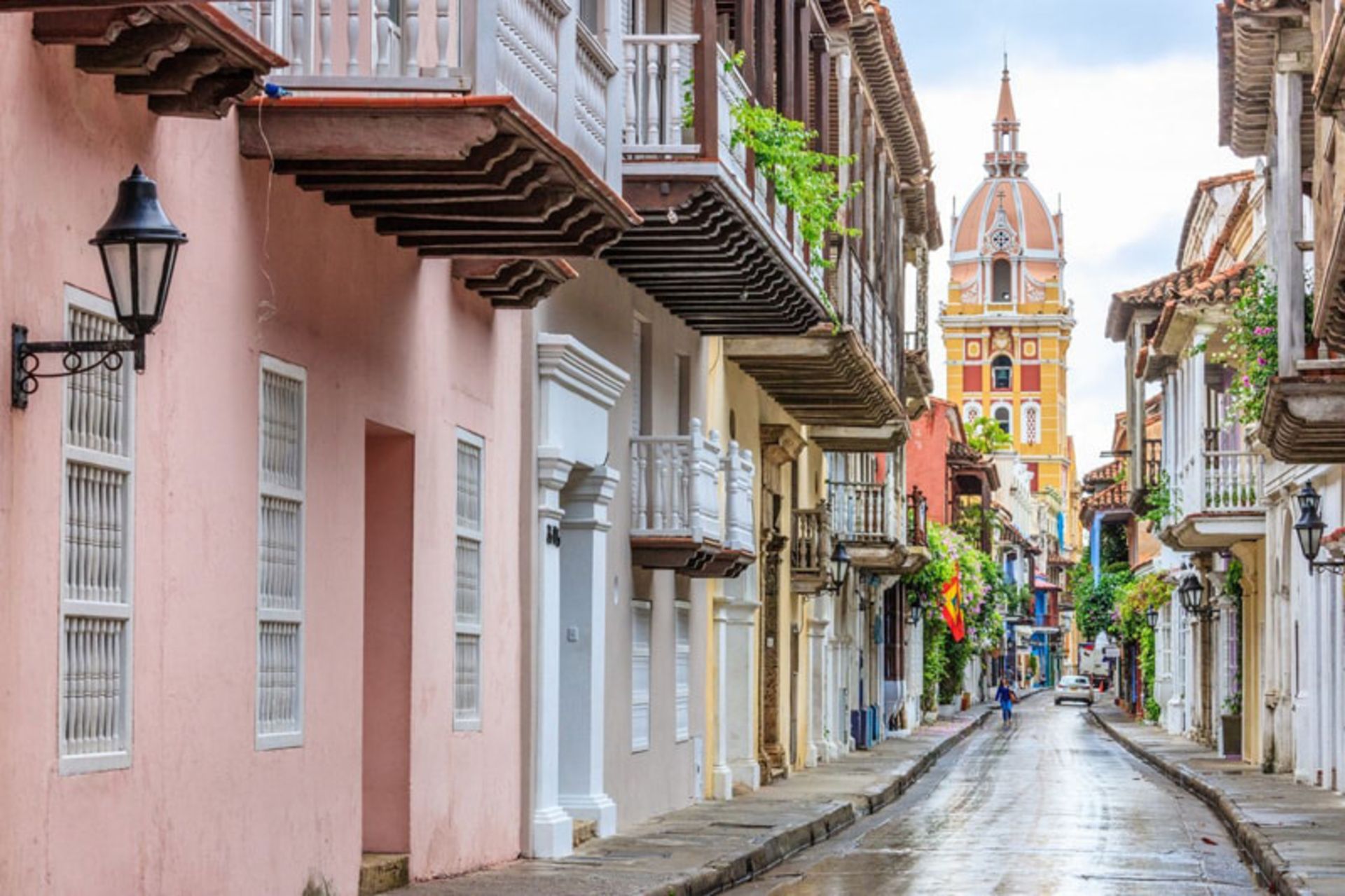Colorful Street in Carthaneh, Colombia with historic buildings and church tower in the background