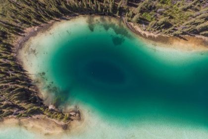 Aerial image of the emerald lake and the surrounding trees in the Yukan territory