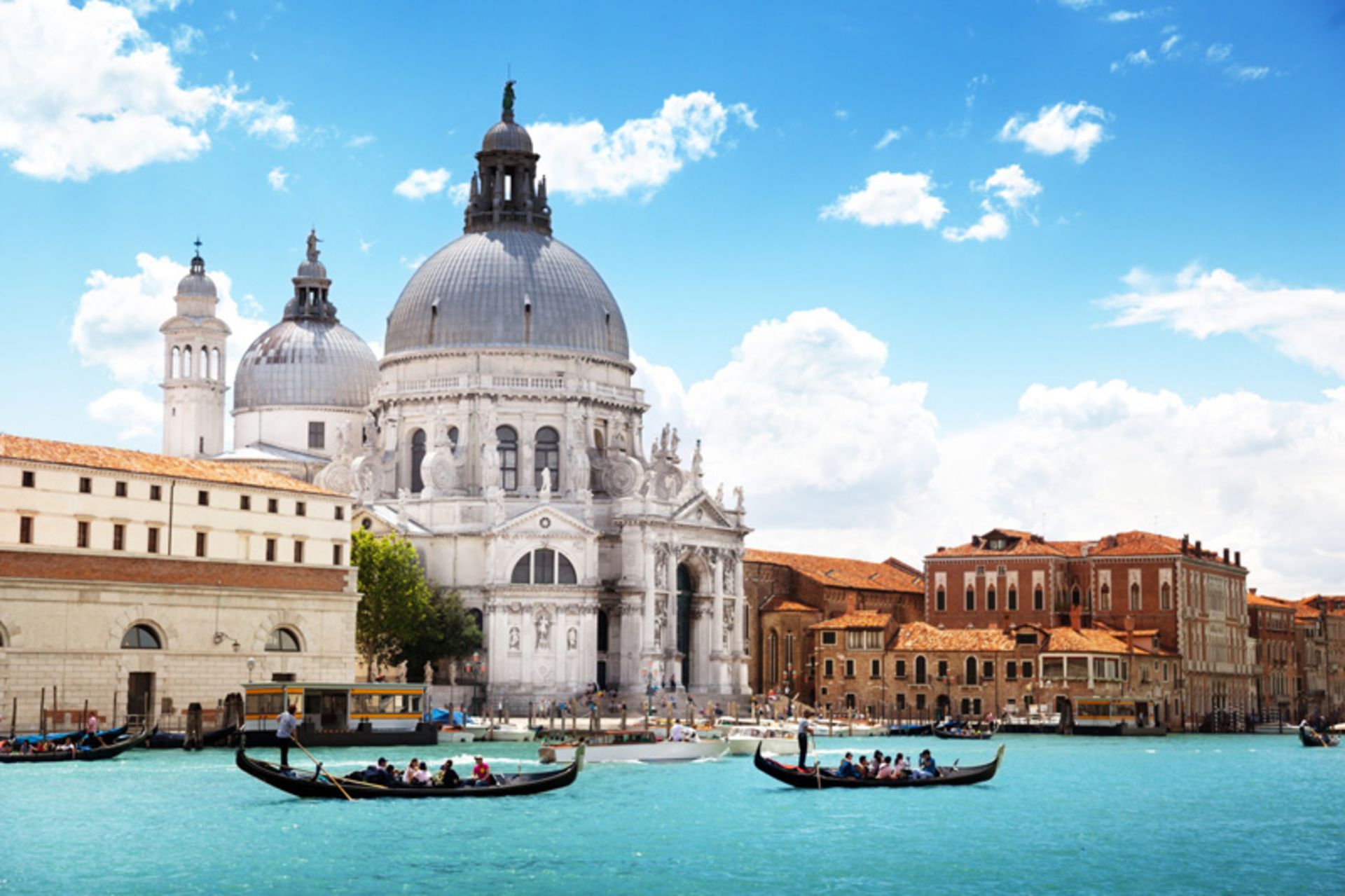 Two tourist boats on the Venice Canal and opposite the church dome