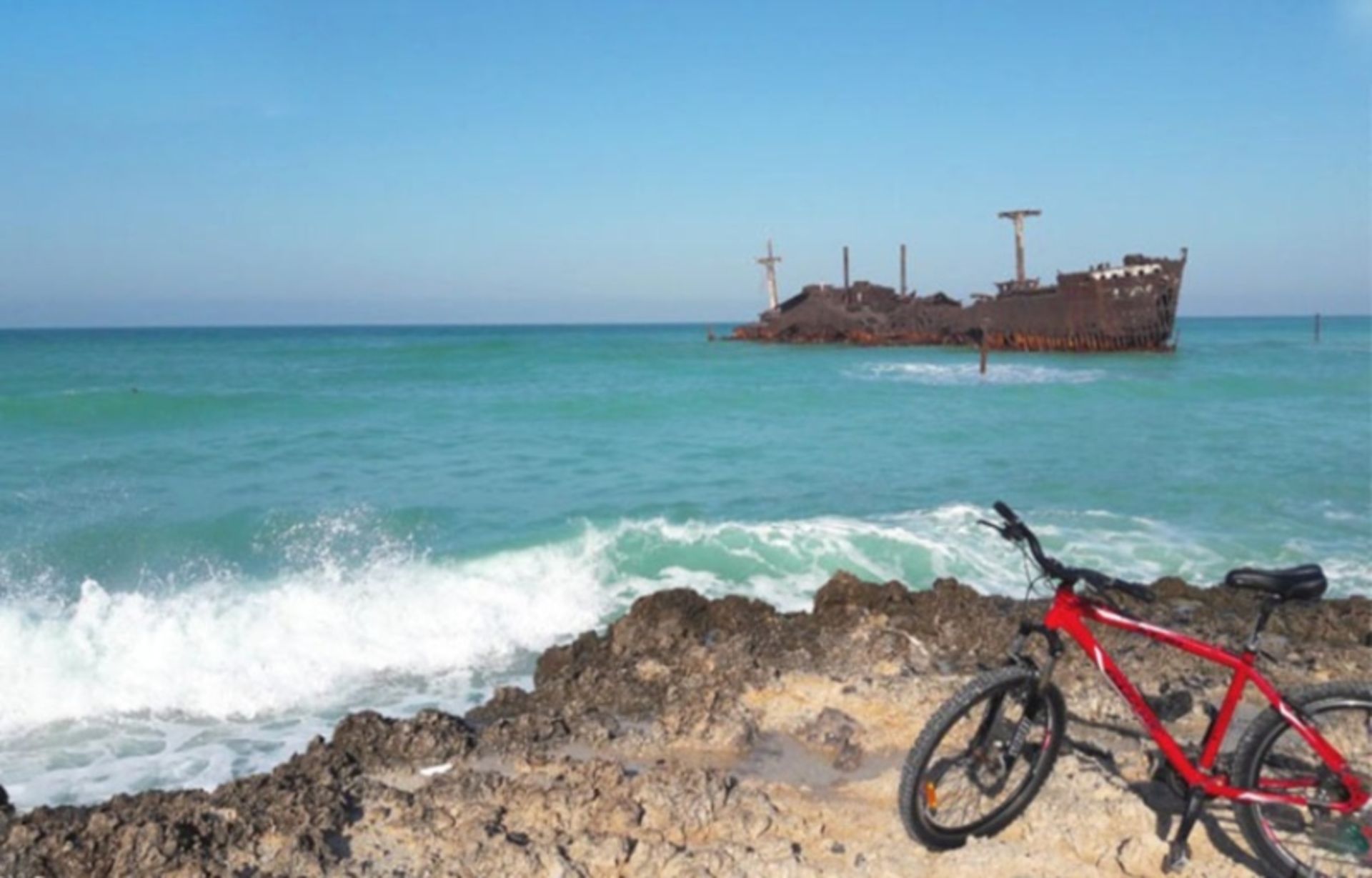 Red bike on the side of the Persian Gulf