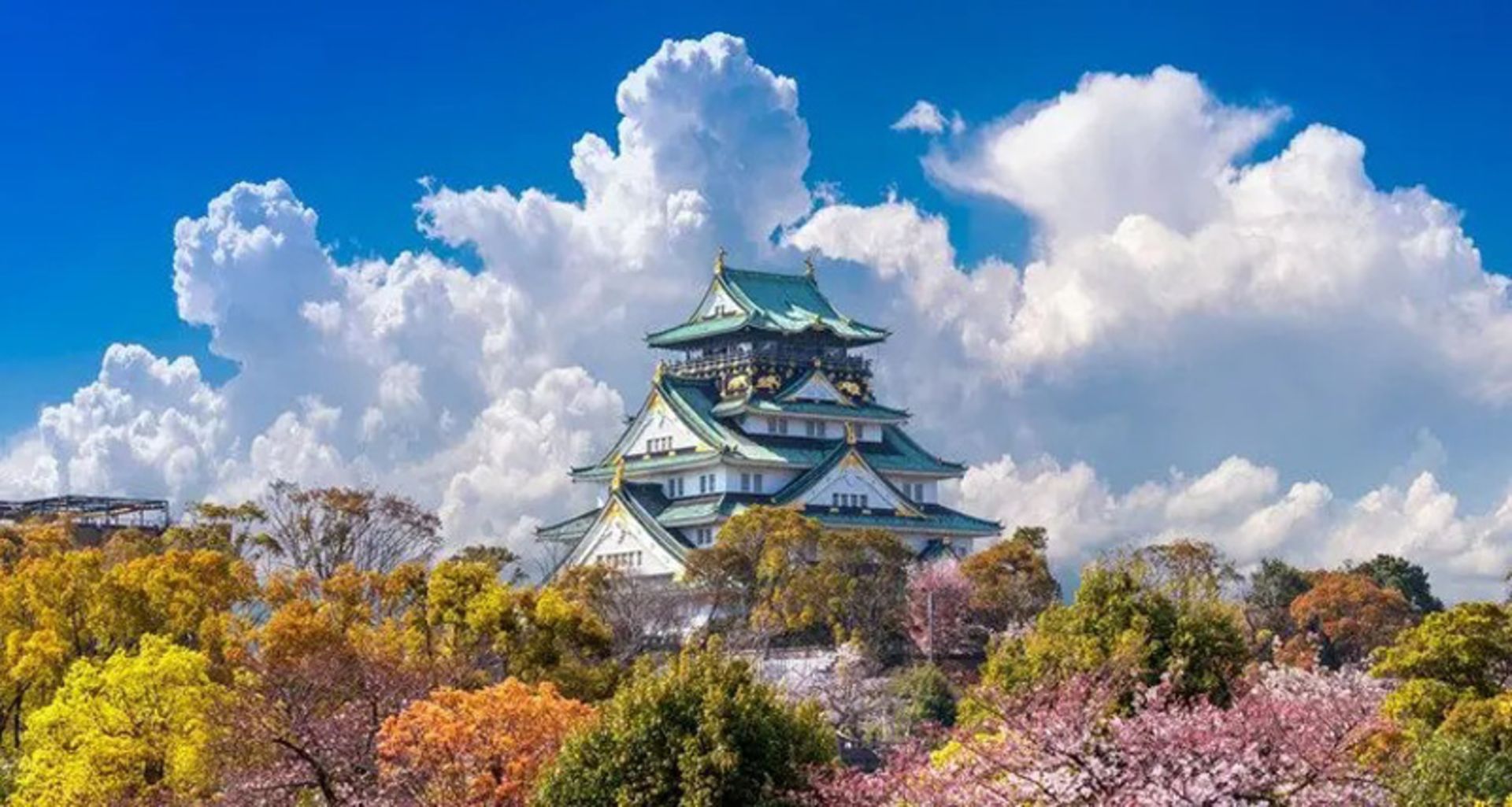 Osaka Castle among the trees and cloudy sky of Japan
