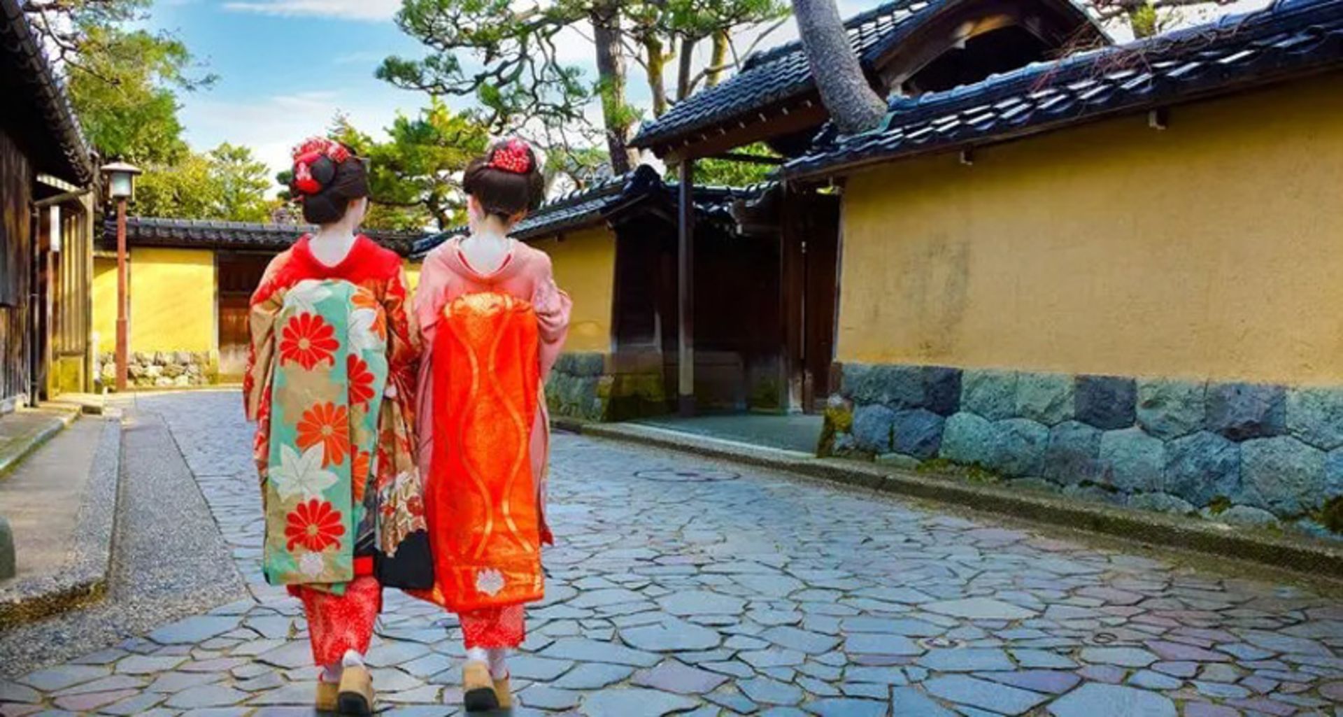 Two women with red kimono in the streets of Kanazawa, Japan