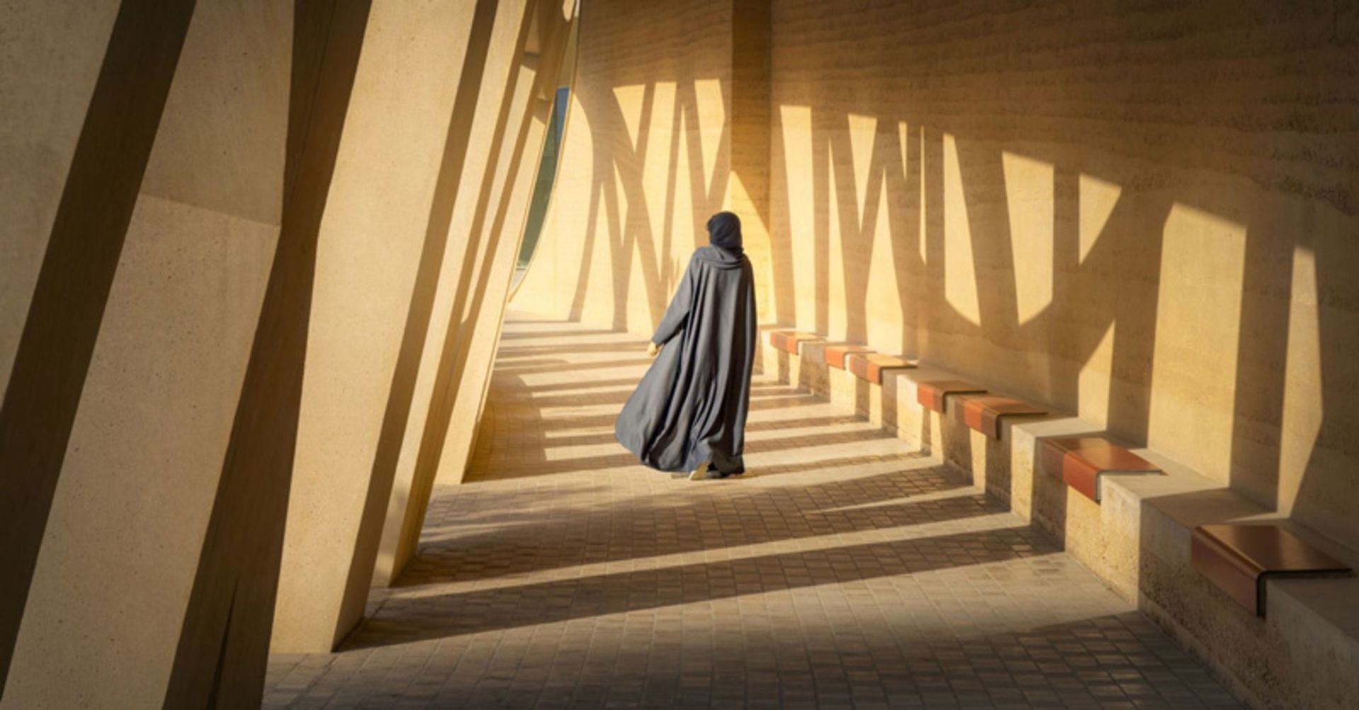 A visitor wearing a hijab walking in the cultural center of Atra