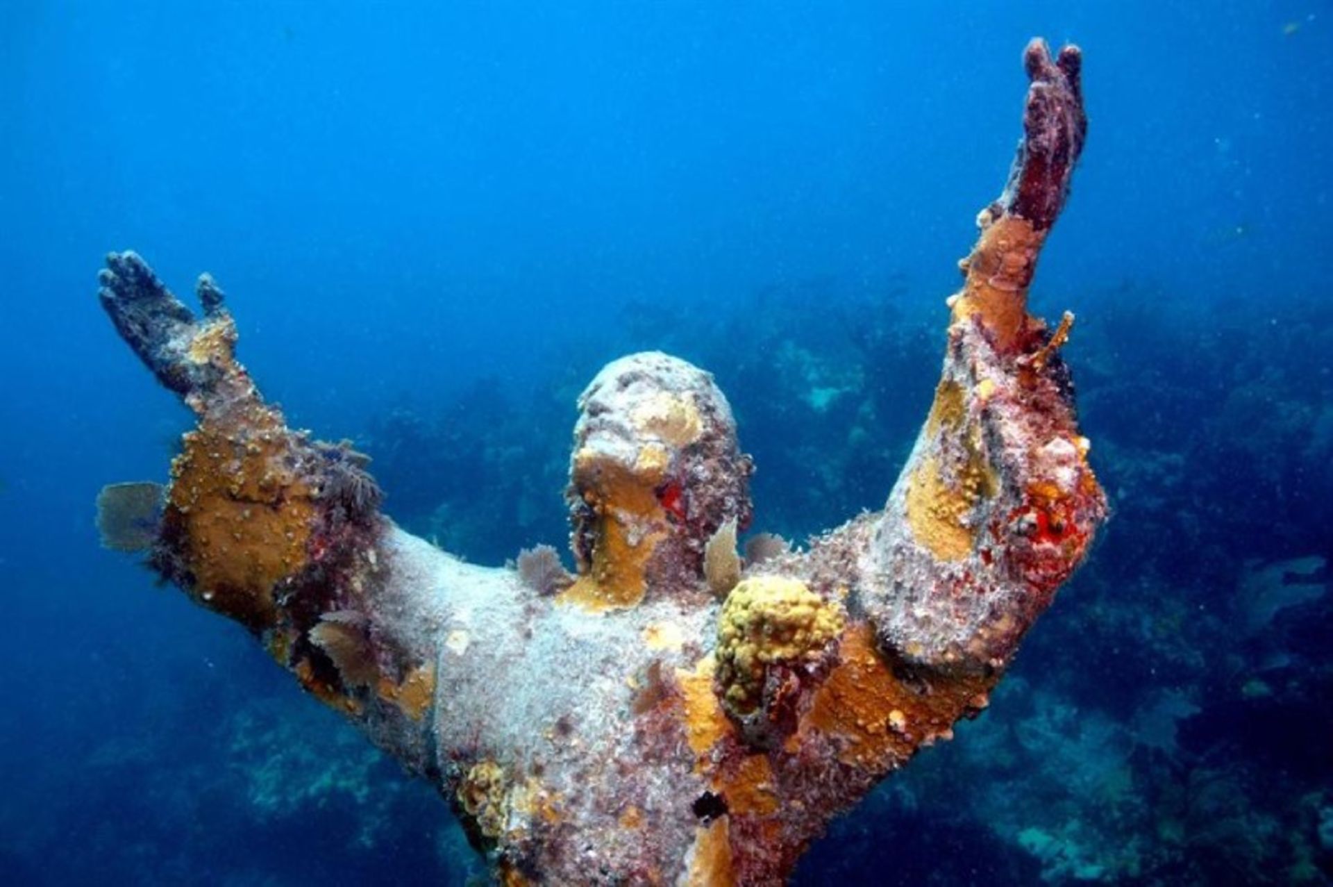 Statue of Christ underwater with open hands and face up in Italy