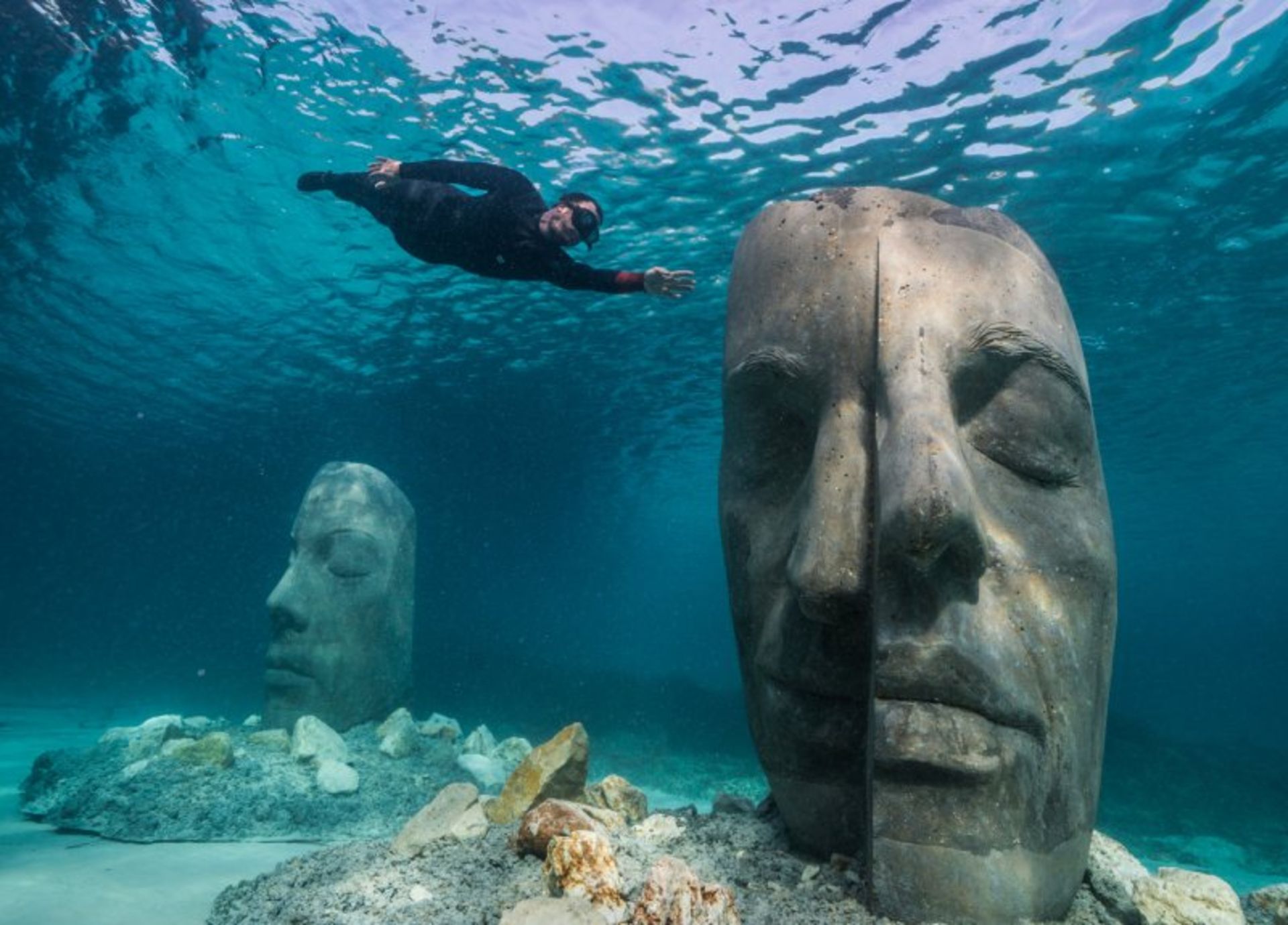 Diver next to the sculptures in the underwater museum