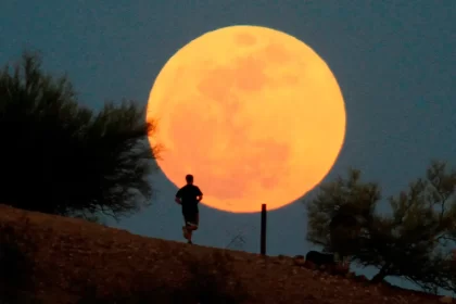 A runner traverses a hill course in front of a supermoon over Papago Park in Phoenix in May 2012.