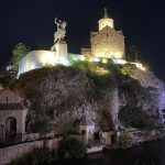 Statue of a man riding a horse on a rock in Batumi