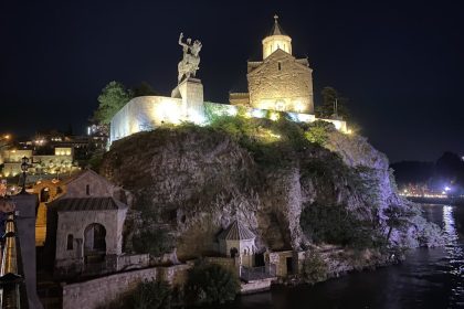 Statue of a man riding a horse on a rock in Batumi