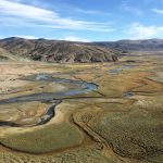 Aerial view of a wide valley with a winding river around Hanle