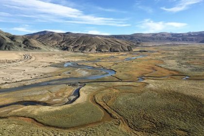 Aerial view of a wide valley with a winding river around Hanle